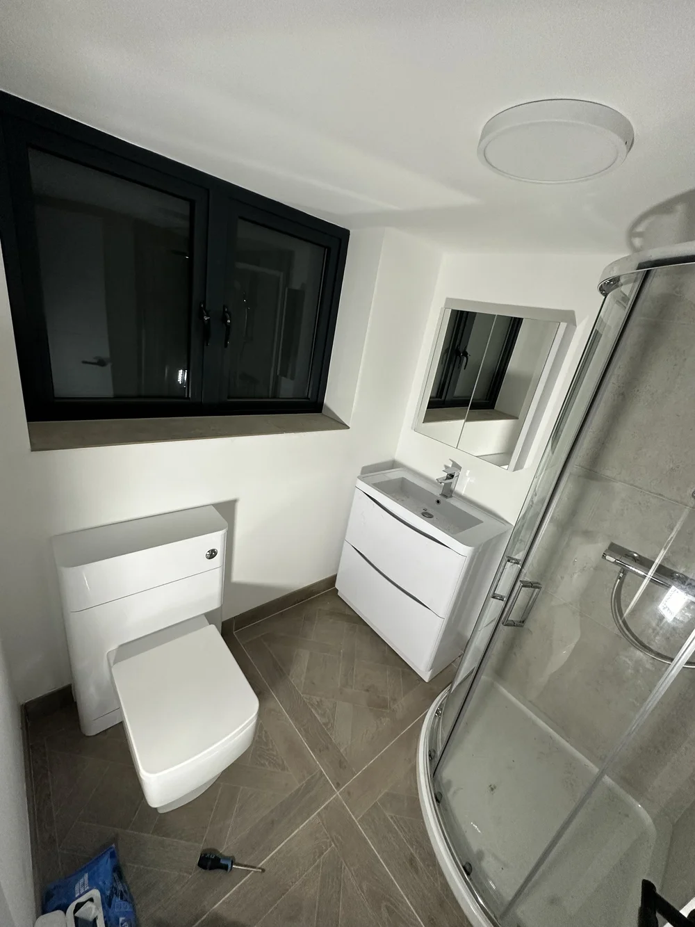 Compact ensuite with quadrant shower enclosure, wall-hung vanity and back-to-wall WC — bathroom installation